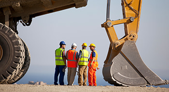 construction workers discussing project plans at a busy worksite